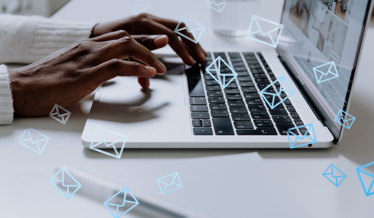 an up close photo of a pair of hands typing on a laptop. There are blue email graphic overlays throughout the image